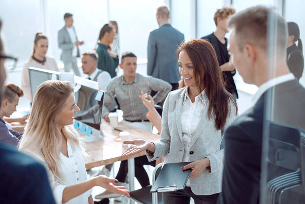"liiketoiminnan nainen puhuu kollegoilleen seisoo toimistossa
" - Valokuva, kuva