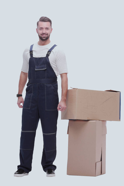 v plném růstu. usmívající se muž stojící u lepenkových krabic - Fotografie, Obrázek
