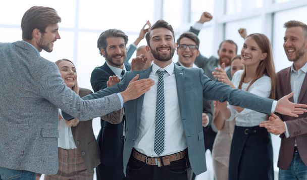 jubilant young businessman accepting the congratulations of his business team. - Foto, Bild