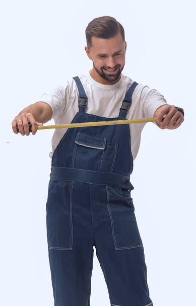 v plném růstu. usmívající se muž se stavební páskou opatření - Fotografie, Obrázek