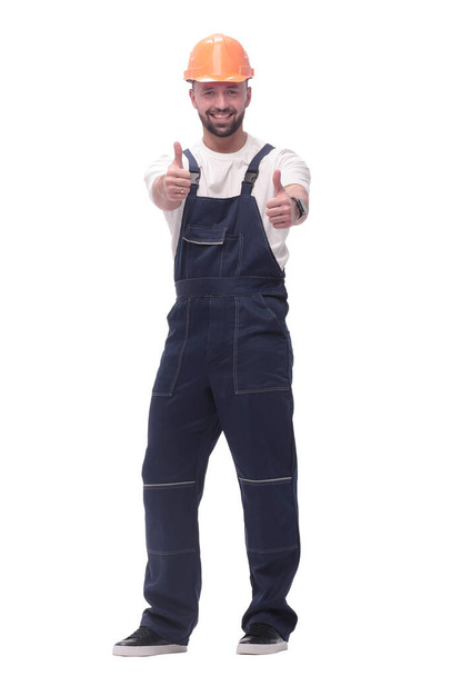 "smiling man in overalls showing thumbs up . isolated on white" - Photo, Image