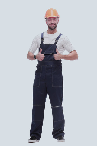 "smiling man in overalls showing thumbs up . isolated on white" - Photo, Image