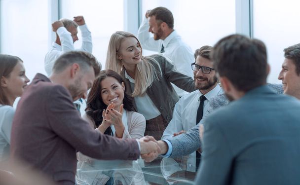 χαμογελαστοί επιχειρηματικοί συνεργάτες που σφίγγουν το χέρι, στα χειροκροτήματα της ομάδας - Φωτογραφία, εικόνα