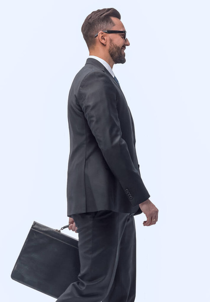 "side view . businessman with leather briefcase stepping forward." - Foto, afbeelding