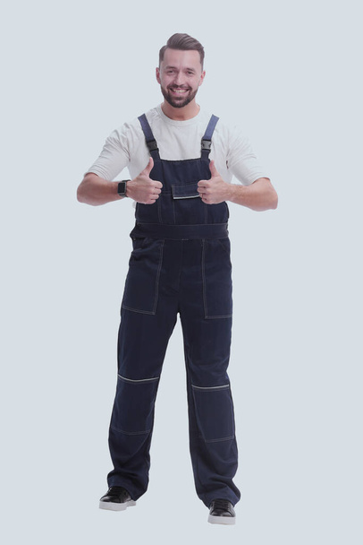 "in full growth. friendly man in overalls showing thumbs up" - Fotografie, Obrázek