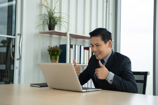 Aprendizaje en línea, Reunión, trabajo y E concepto de aprendizaje. Casual asiático hombre de negocios estudiando curso en línea, reunión a través de ordenador portátil en la oficina. - Foto, imagen