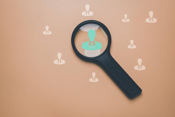 HRM or Human Resource Management, Magnifier glass focus to manager icon which is among staff icons for human development recruitment leadership and customer target group concept. - Photo, Image