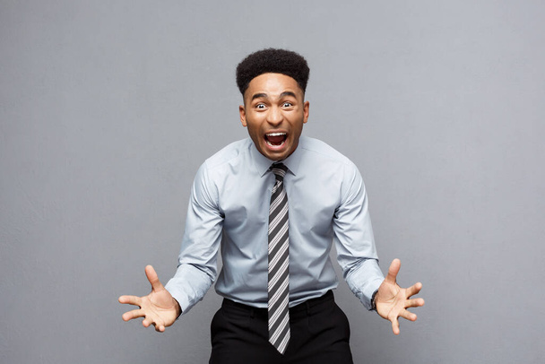 "Concept d'entreprise - confiant jeune Afro-Américain joyeux montrant les mains devant lui avec expression déçue sur fond gris
." - Photo, image