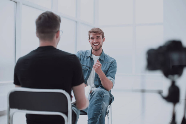"dwóch młodych mężczyzn rozmawia w studiu telewizyjnym" - Zdjęcie, obraz