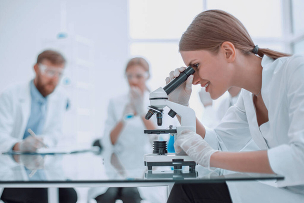 científica femenina utilizando un microscopio en un laboratorio químico - Foto, Imagen