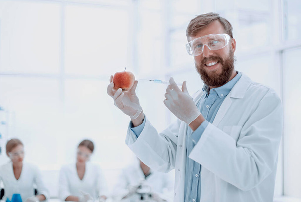 esperto con una mela in piedi in laboratorio - Foto, immagini