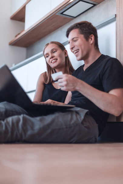 νεαρό ζευγάρι κάνει online παραγγελία στο νέο τους διαμέρισμα - Φωτογραφία, εικόνα