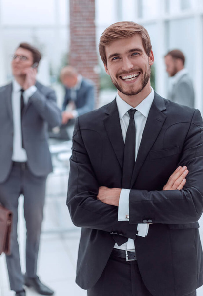 sorridente homem de negócios de pé em um escritório moderno
 - Foto, Imagem