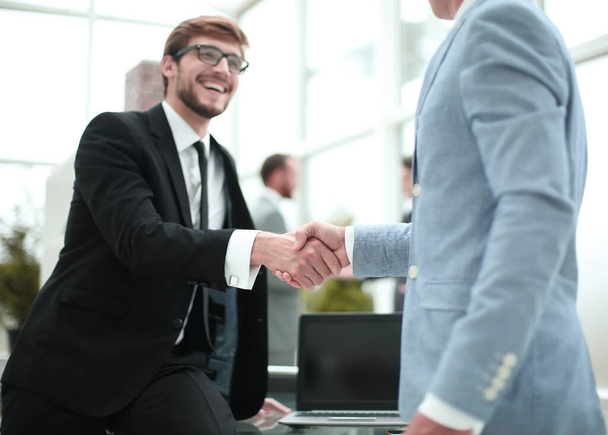 glücklicher junger Unternehmer beim Händeschütteln mit seinem Geschäftspartner - Foto, Bild