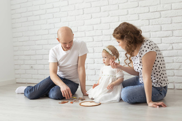 Bambina con impianto cocleare gioca a casa con madre e padre. Compromissione dell'udito, diversità e apparecchi acustici - Foto, immagini