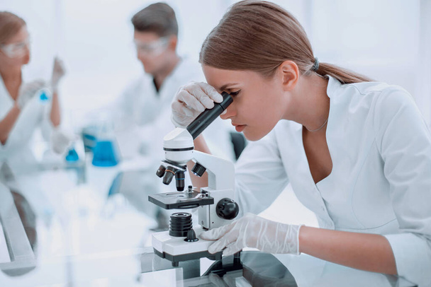 "naispuolinen tutkija, joka käyttää mikroskooppia kemiallisessa laboratoriossa" - Valokuva, kuva