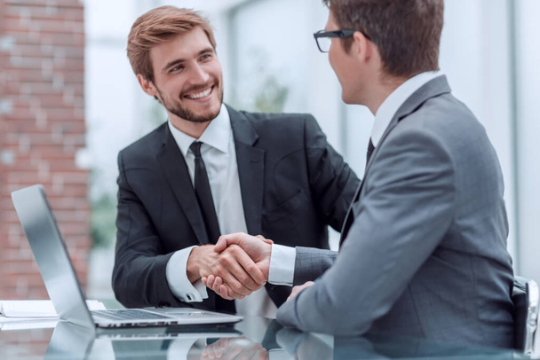 business colleagues shaking hands while sitting at the Desk - Photo, Image
