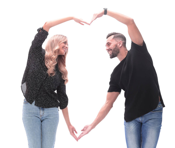 in full growth. a loving young couple making a heart out of their hands - Foto, Bild