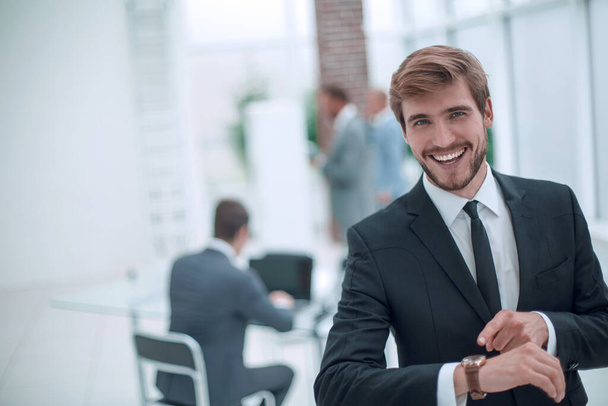 smiling businessman pointing to his wrist watch. - Foto, Bild