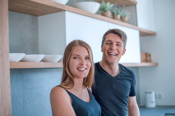 gelukkige jonge paar staande in hun nieuwe appartement - Foto, afbeelding