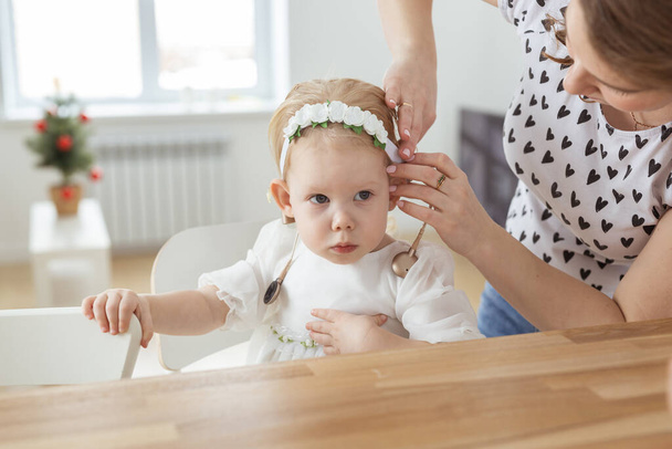 "Mother helps to put on cochlear implant for her deaf little daughter. Hearing aid and deafness and diversity concept" - Foto, imagen