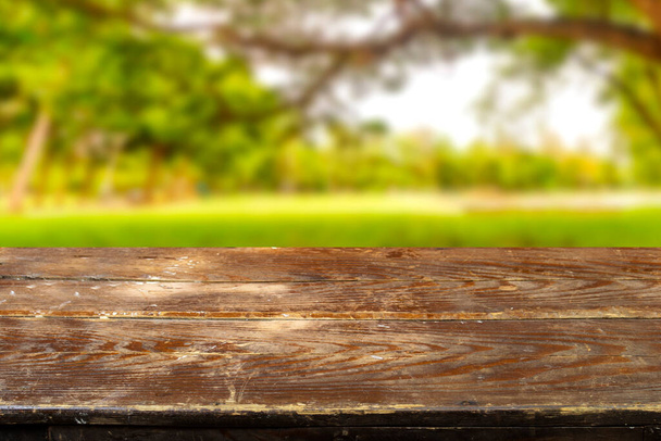 Empty wood plank table top with blur park green nature background bokeh light, Mock up for display or montage of product,Banner or header for advertise on social media and Spring and Summer concept - Foto, immagini