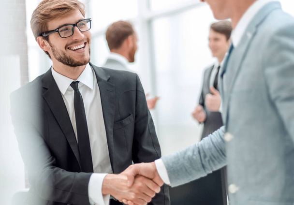 ビジネスパートナーと握手をするビジネスマンを笑顔で - 写真・画像