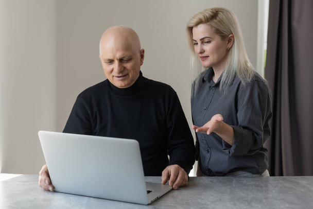 Vorderseite glückliche ältere Siebzigerjahre grauhaarige Männer lernen mit Computersoftware mit fürsorglicher erwachsener Tochter, pensionierten Alten und modernem Technologiekonzept. - Foto, Bild