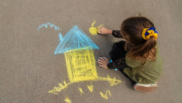 Children draw the Ukrainian flag house on the pavement. Selective focus. - Foto, immagini