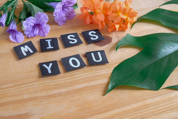 Miss you tag with flower on wood table. - Foto, Imagen
