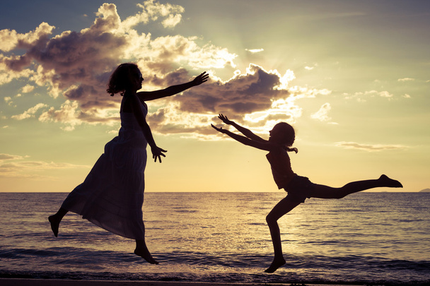mother and  daughter playing on the beach - Фото, изображение