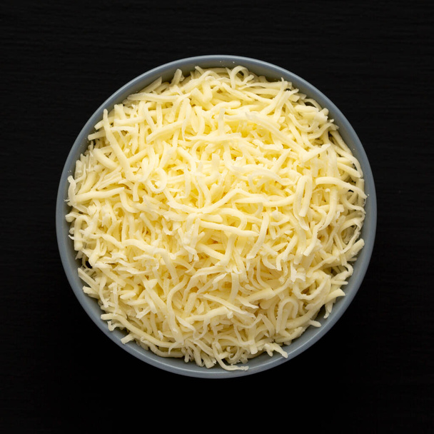 https://cdn.create.vista.com/api/media/small/618765774/stock-photo-shredded-mozzarella-cheese-bowl-black-surface-top-view-flat-lay