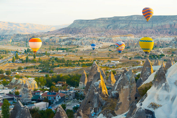 10.11.2022カッパドキア,トルコ.カッパドキアの平和的なトルコの都市を飛んで鮮やかな色のいくつかの熱気球。興味深い風景や有名な洞窟の空中ビュー。高品質の写真 - 写真・画像