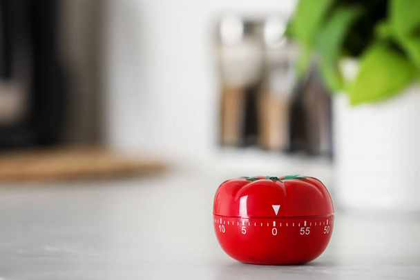 Kitchen timer in shape of tomato on white table indoors. Space for text - Photo, Image