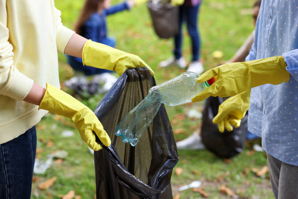 Women with plastic bag collecting garbage in park, closeup - Photo, image