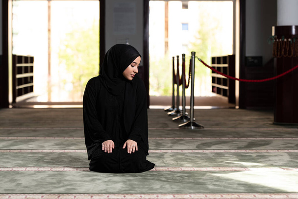 Beautiful Muslim Woman in Hijab Dress Sitting in Mosque and Praying - Foto, immagini