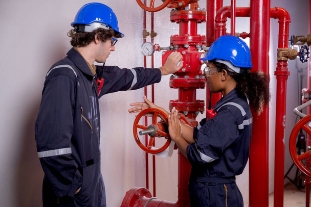 Young woman and man engineer check and examining pipeline and discussion in the factory, mechanic or technician inspector plumber valve and talking together, industrial and maintenance concept. - Foto, Imagen
