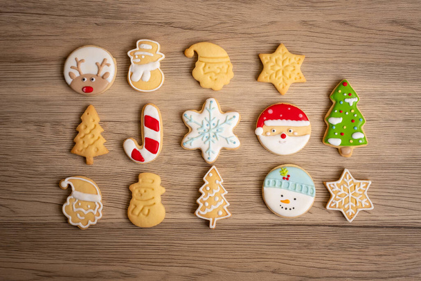 Wesołych Świąt z domowymi ciasteczkami na tle drewnianego stołu. Boże Narodzenie, impreza, wakacje i szczęśliwego Nowego Roku koncepcja - Zdjęcie, obraz