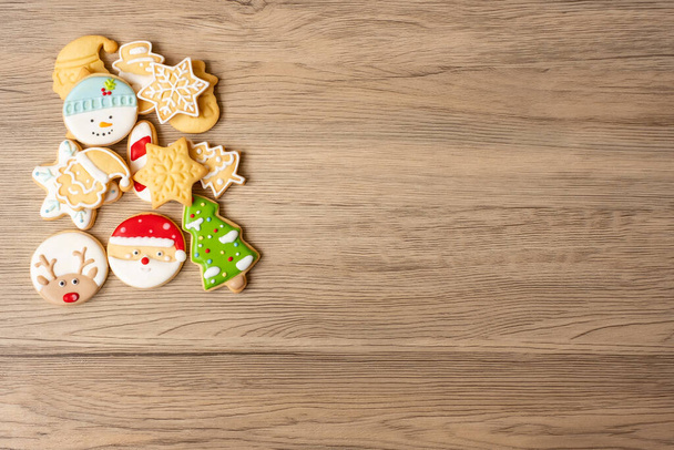 Vrolijk kerstfeest met zelfgemaakte koekjes op houten tafel achtergrond. Kerstmis, feest, vakantie en gelukkig nieuwjaarsconcept - Foto, afbeelding