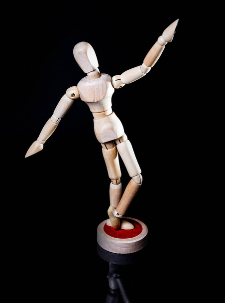 Obrázek padající dřevěné figuríny na černém pozadí, dřevěná figurína představuje různé pózování - Fotografie, Obrázek