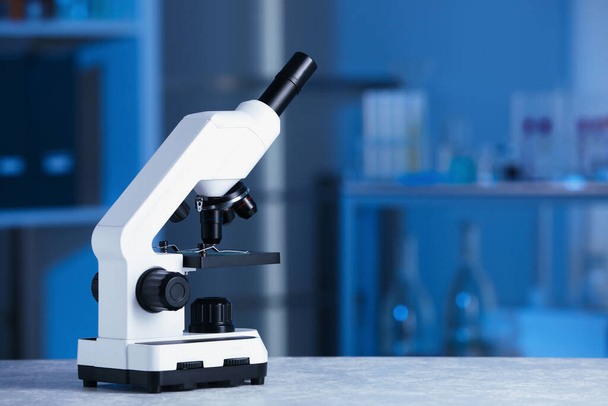 Laboratuvarda gri masada modern tıbbi mikroskop, metin için alan - Fotoğraf, Görsel