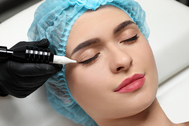 Young woman undergoing procedure of permanent eye makeup, closeup - Foto, immagini