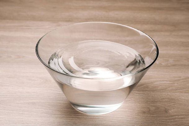 Glass bowl with water on wooden table - Photo, image