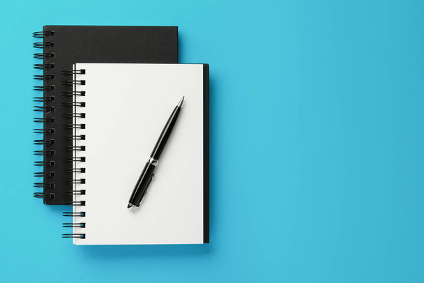 Notebooks and pen on light blue background, top view. Space for text - Foto, immagini