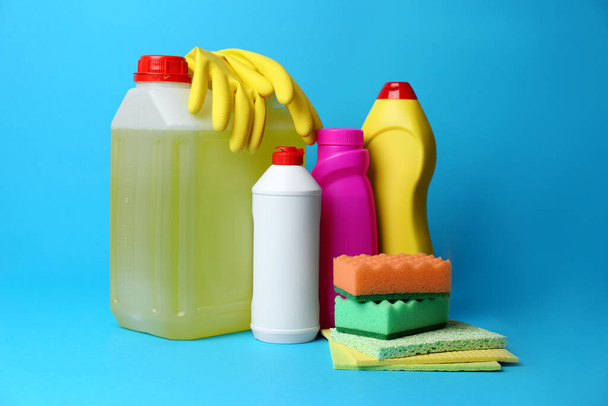 Cleaning supplies and tools on light blue background - Foto, afbeelding