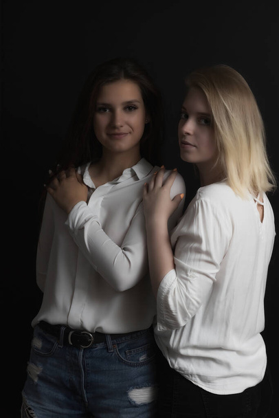 Portrait of two beautiful young women posing in studio. Vertically.  - Foto, afbeelding
