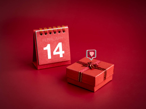 3d любить як іконки серця, що плавають на маленькій червоній подарунковій коробці з лютим, 14 день Валентина на парковому календарі на червоному тлі. Особливий подарунок для Валентина, мінімальний стиль. - Фото, зображення