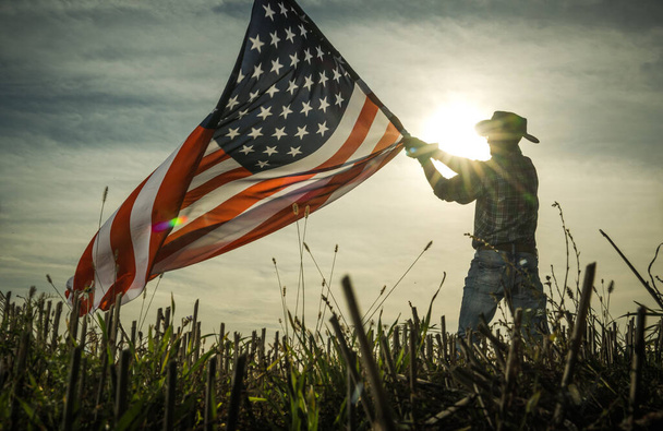 Man Shows Love of Country by Waving American Flag (em inglês). Cowboy patriótico. - Foto, Imagem