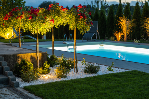 Современный иллюминированный открытый бассейн, бассейн и задний двор. Ночная сцена. - Фото, изображение