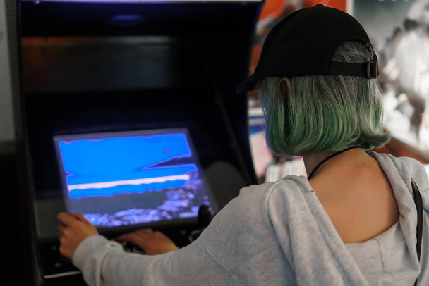 Teenage girl is playing arcade video game. - Foto, Imagen